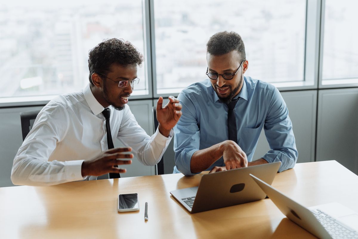 Two professionals reviewing a Google Ads account together on a laptop in an office