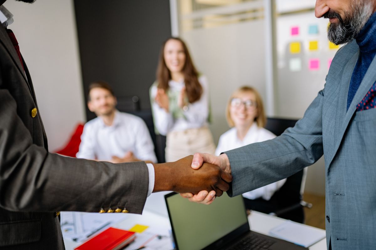 Handshake between two colleagues in a professional office setting