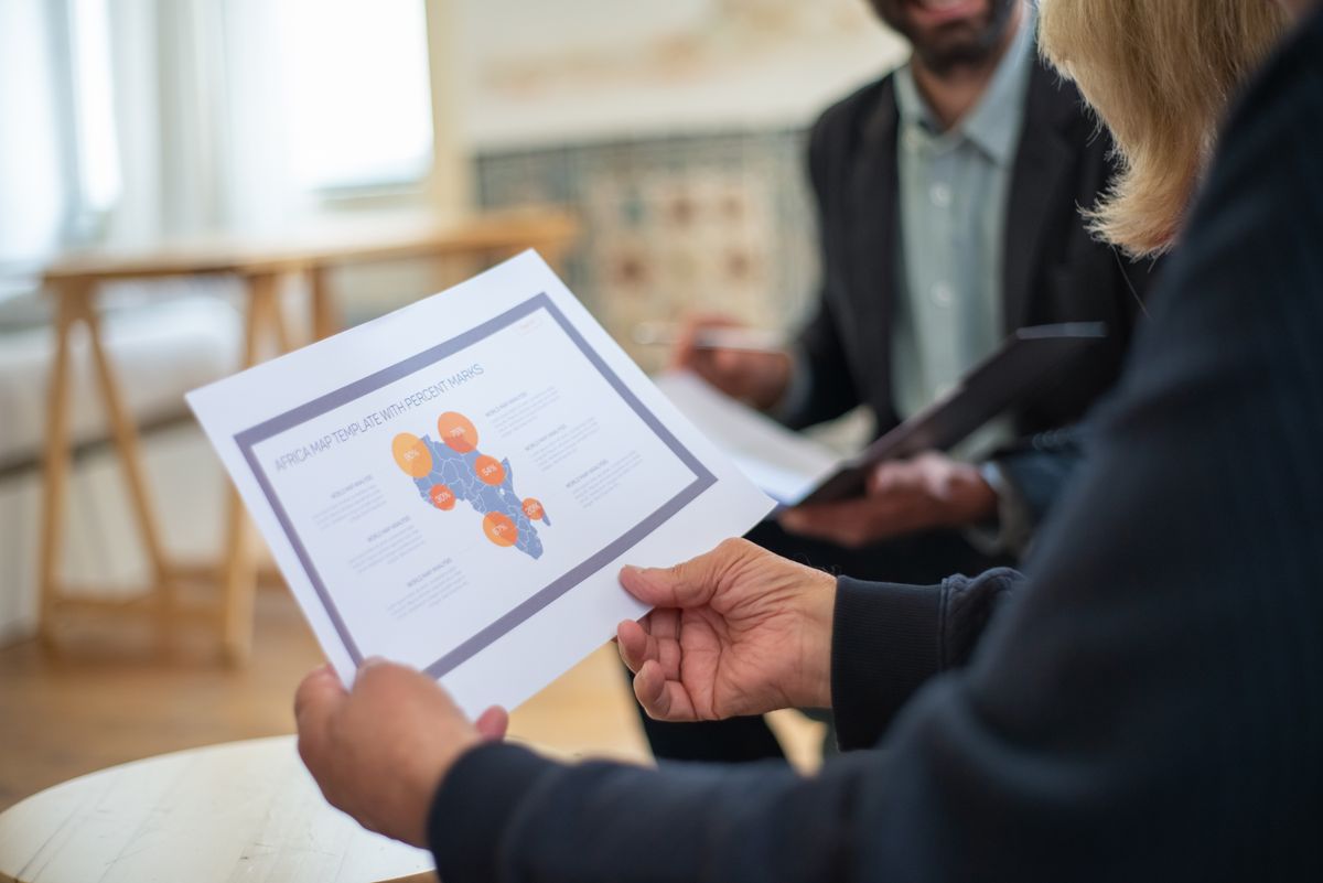 Three professionals discussing a data presentation in an office